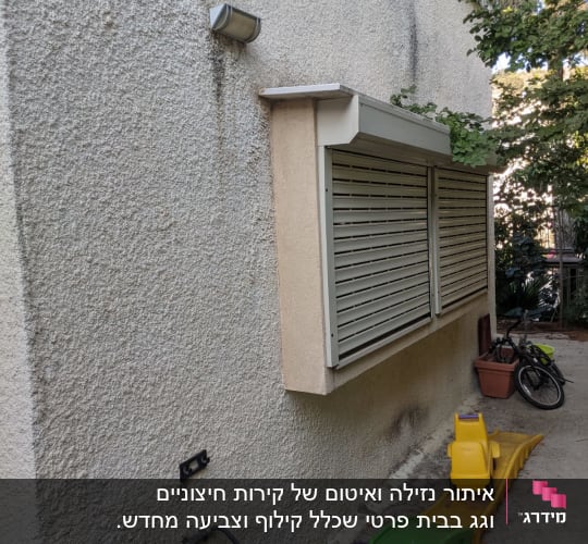 קיר חיצוני עם תריסים סגורים וצינור מים